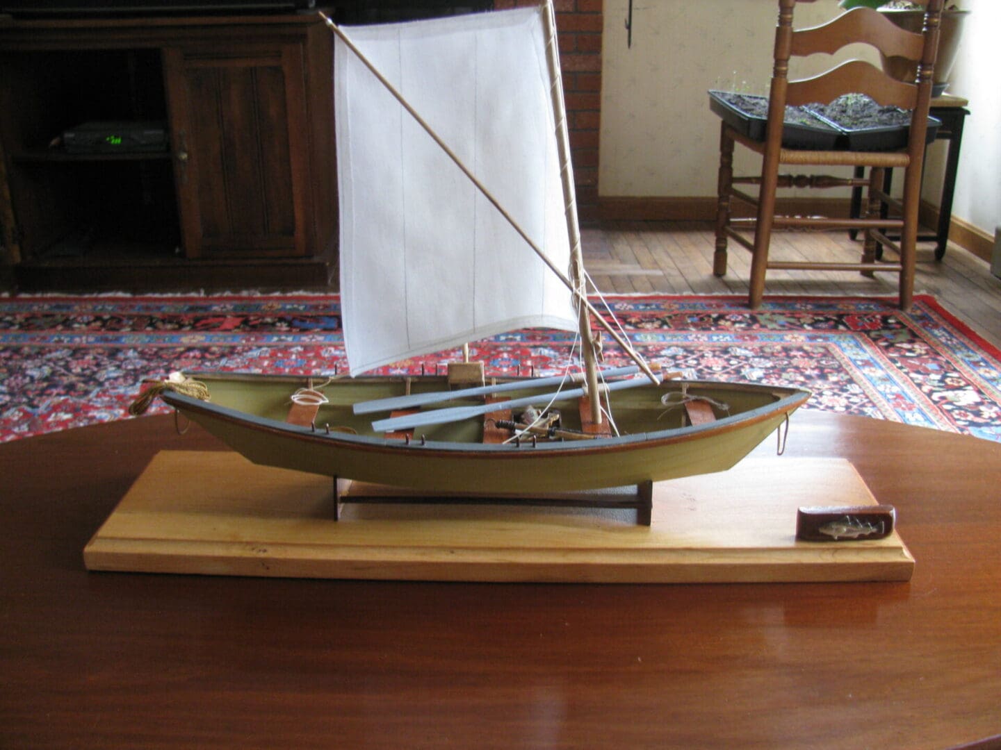 A model boat on top of a wooden table.