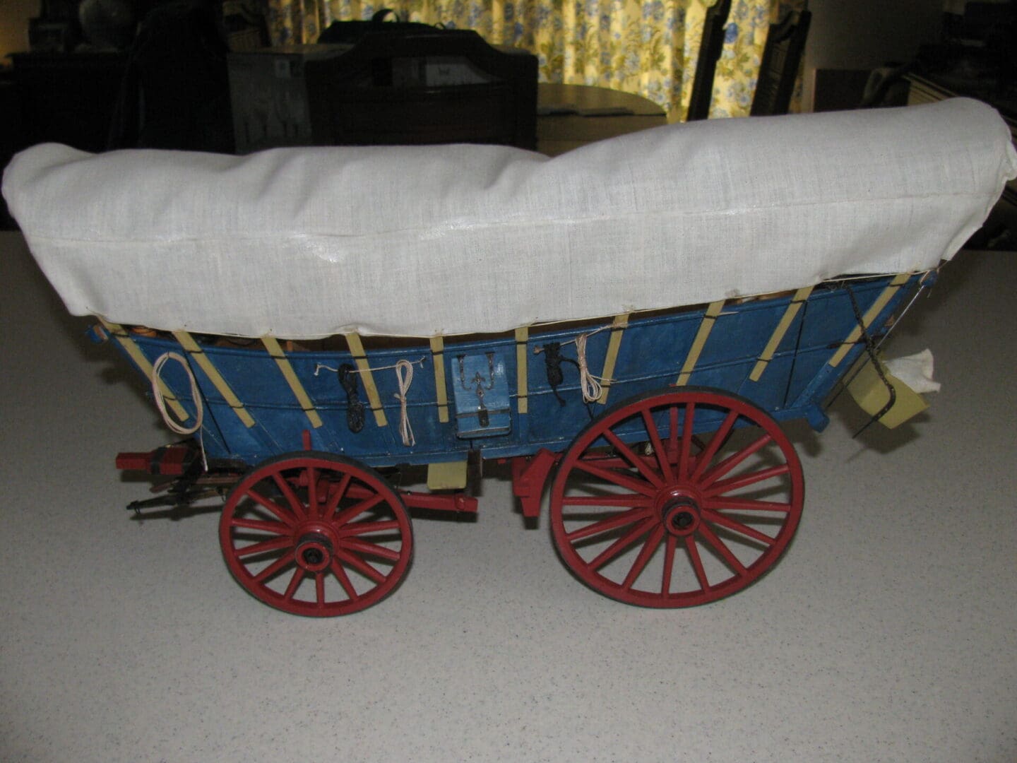 A blue wagon with white cover on the side.