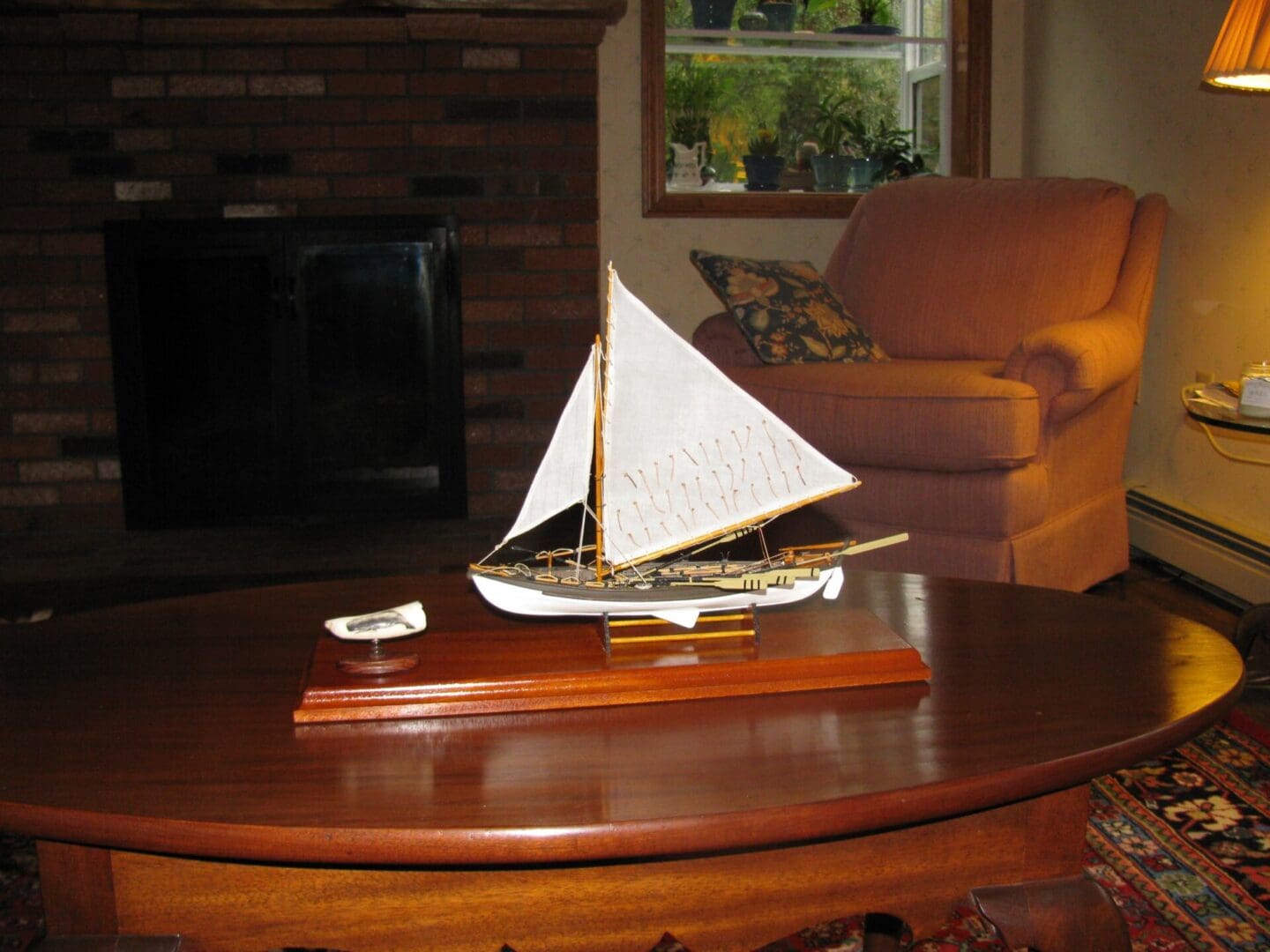 A small sailboat on top of a wooden table.