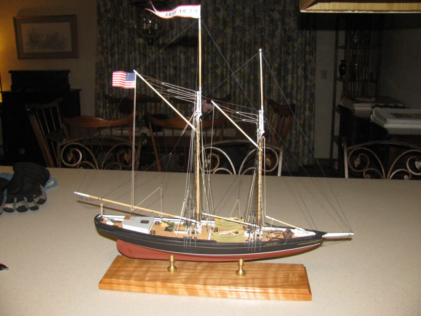 A model of a boat on display in front of a wall.