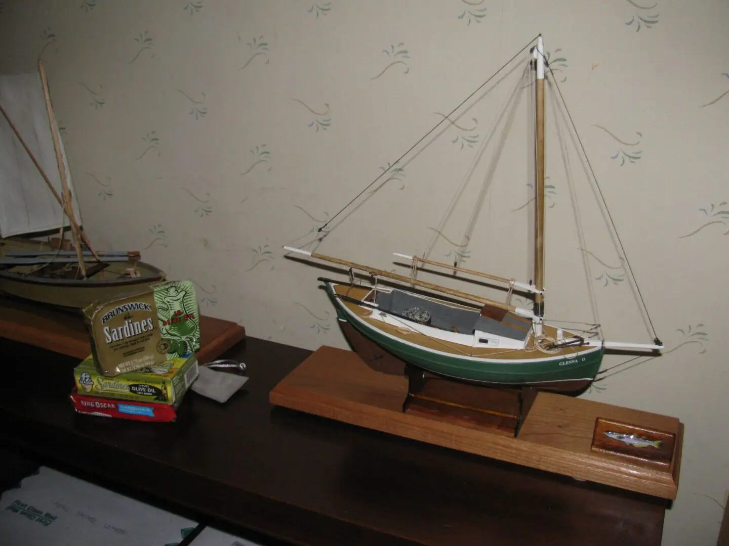 A model boat on display next to a box of cigarettes.