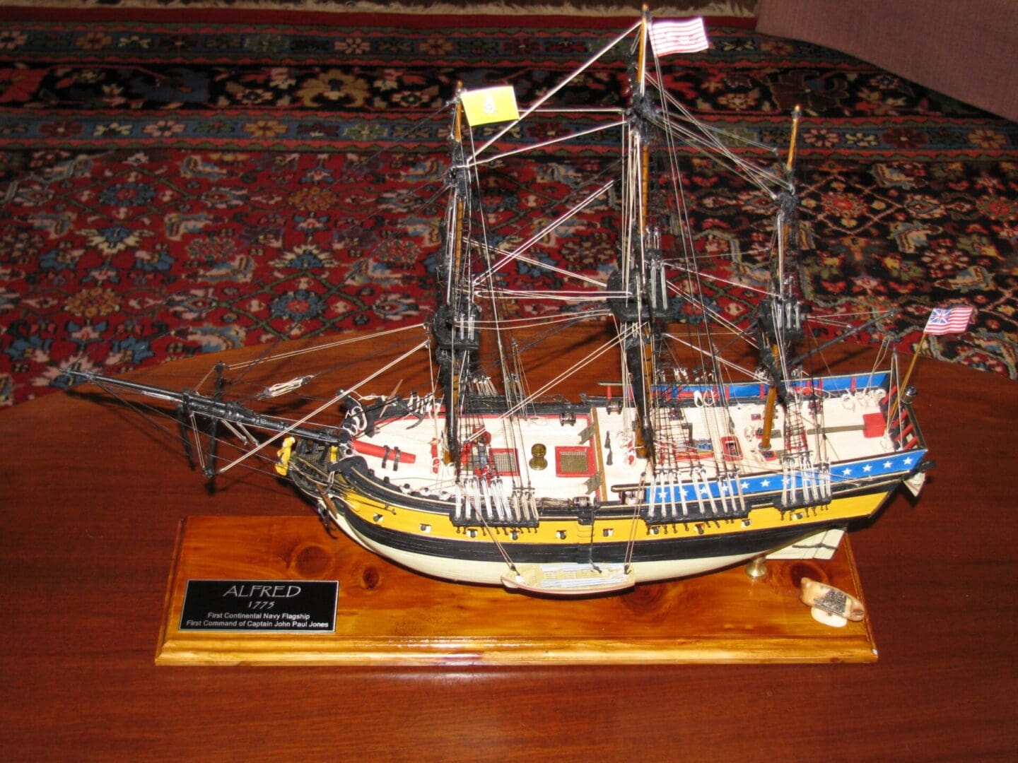 A model of a ship on display in front of the bed.