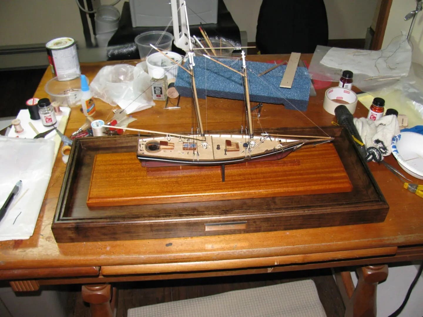 A wooden table with a model boat on top of it.